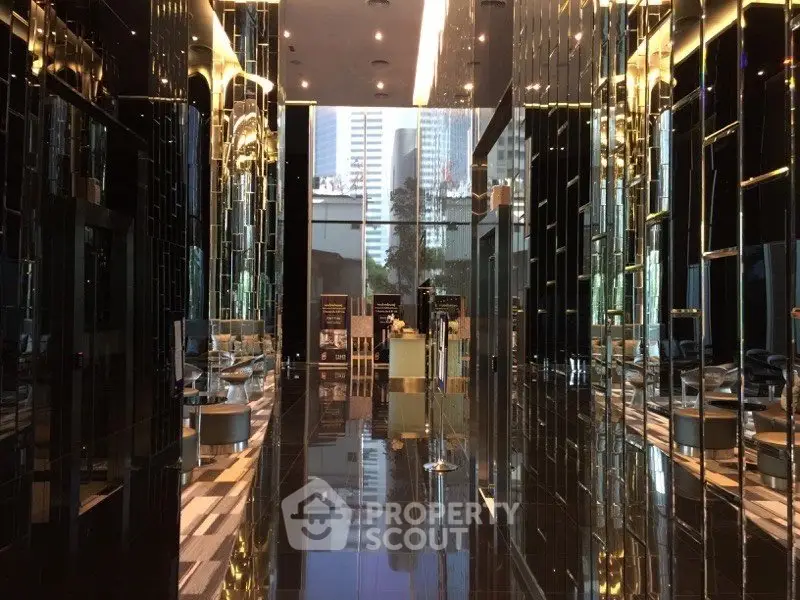 Luxurious modern building entrance with reflective surfaces and elegant design.