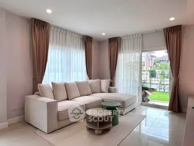 Spacious living room with elegant sofa and garden view, perfect for relaxation and entertaining.