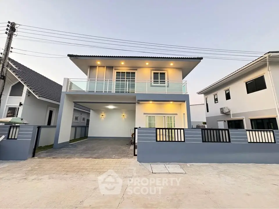 Modern two-story house with balcony and driveway in suburban neighborhood.