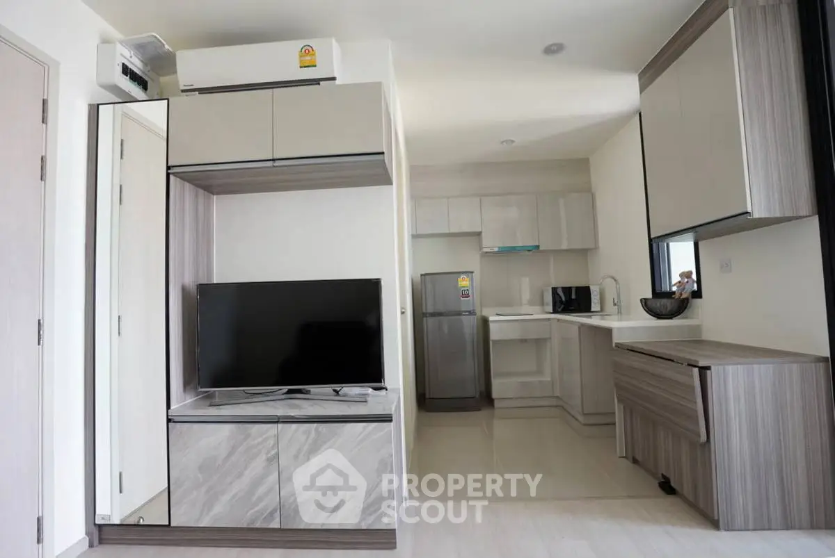 Modern open-plan living room and kitchen with sleek cabinetry and appliances.
