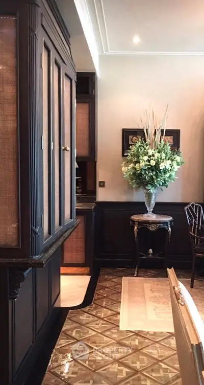 Elegant dining area with classic wooden cabinetry and decorative floral arrangement