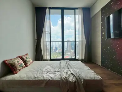 Modern bedroom with large window offering stunning city view, featuring cozy bed and elegant decor.