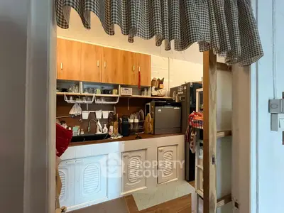 Charming kitchen with wooden cabinets and modern appliances, perfect for cozy home cooking.