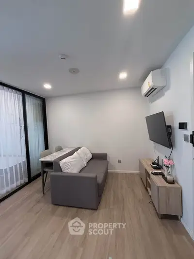 Modern living room with sleek design, featuring a cozy sofa, wall-mounted TV, and elegant decor.