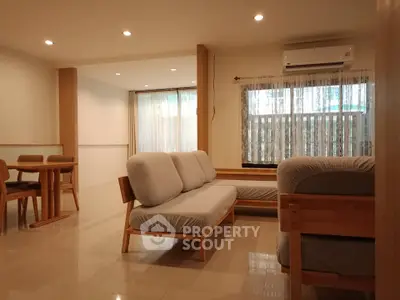 Spacious living room with modern furniture and natural light, perfect for relaxation and entertaining.