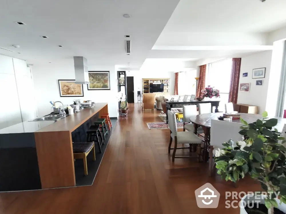 Spacious open-plan living and dining area with modern kitchen and wooden flooring.