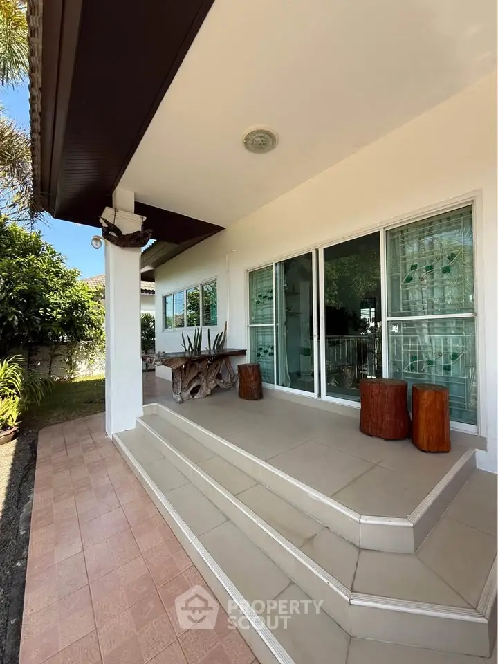 Charming home exterior with inviting patio and lush greenery, perfect for relaxation and outdoor enjoyment.