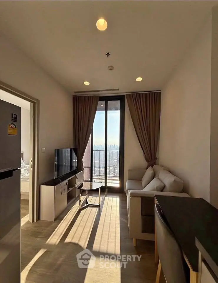 Modern living room with natural light, cozy sofa, and city view from large windows.
