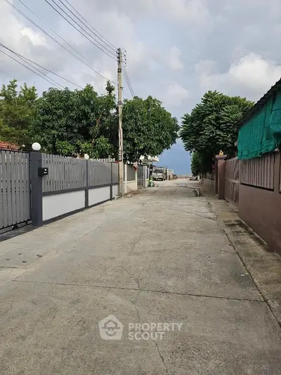 Quiet residential street with gated homes and lush greenery