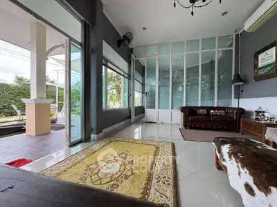 Spacious living room with elegant decor and large windows overlooking a lush garden.