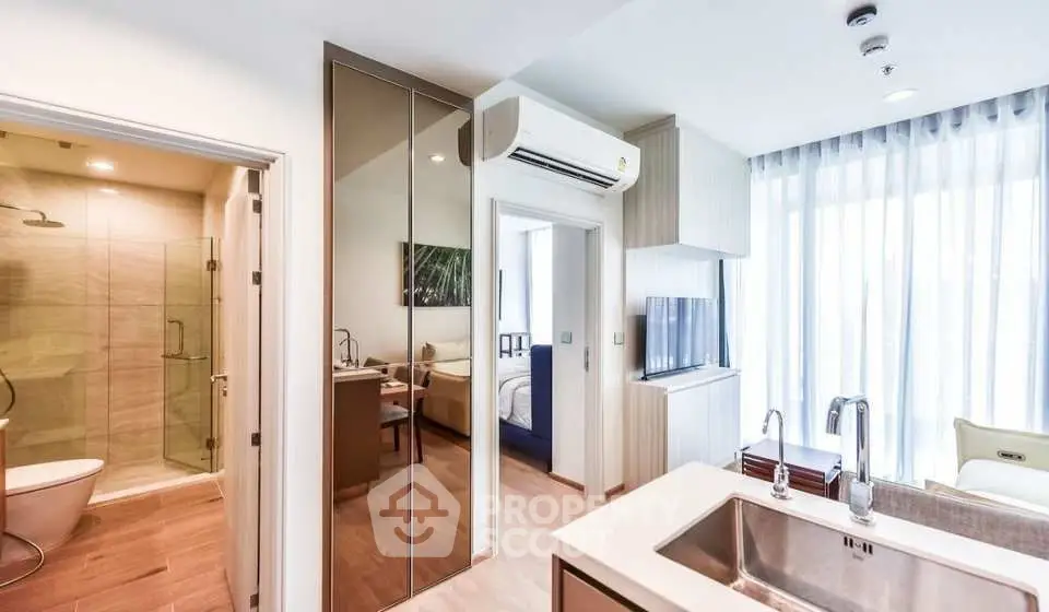 Modern apartment interior with open layout, featuring a sleek kitchen and bright living area.