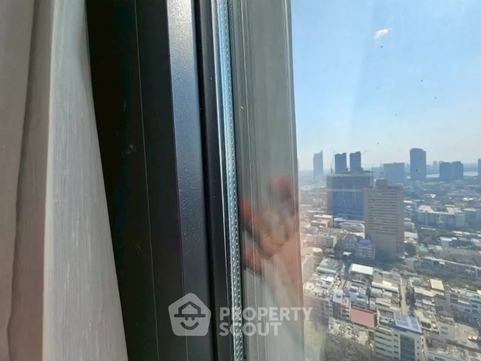 Stunning cityscape view from a high-rise window, showcasing urban skyline and clear skies.