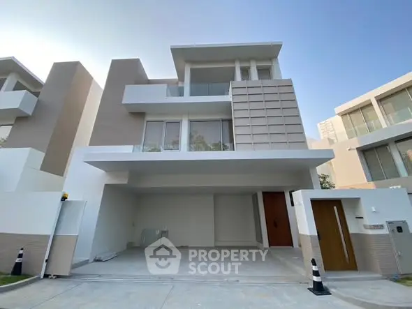 Modern three-story villa with sleek design and spacious garage in upscale neighborhood.