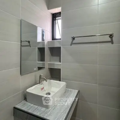 Modern bathroom with sleek sink and wall-mounted mirror