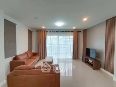 Spacious living room with modern decor and large windows