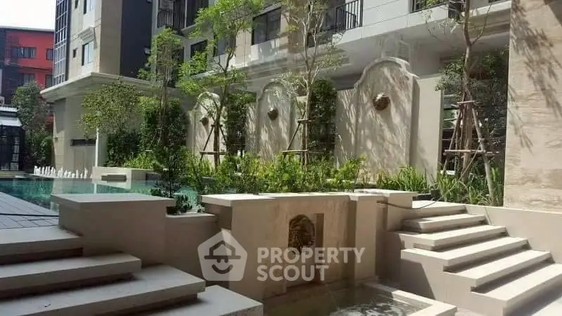 Luxurious residential building with elegant pool and lush garden landscaping.