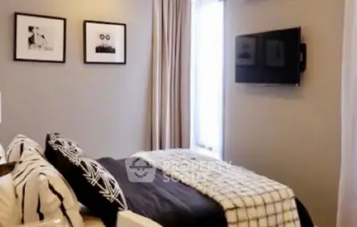 Modern bedroom with stylish decor and wall-mounted TV