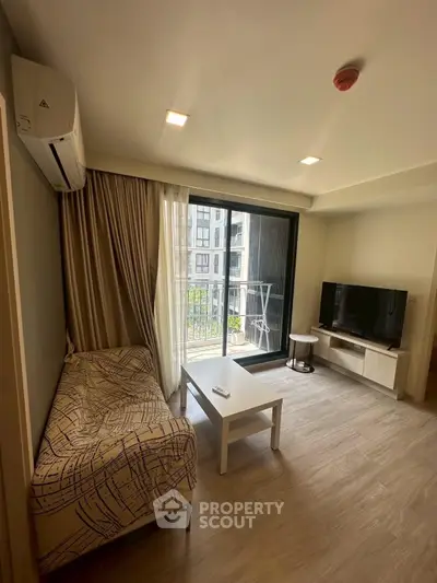 Modern living room with balcony view, featuring sleek furniture and natural light.