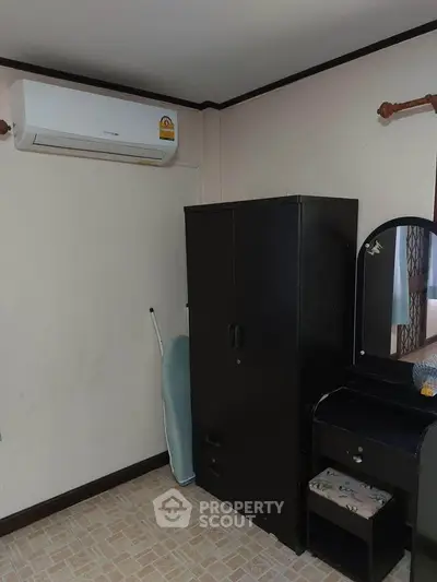 Cozy bedroom corner with air conditioning and stylish black furniture.