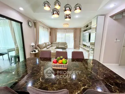Luxurious open-plan living and dining area with elegant marble table and modern decor.