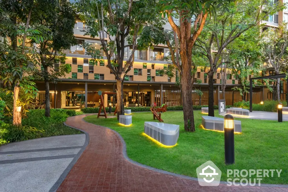 Luxurious garden area with modern seating and ambient lighting in upscale residential complex.