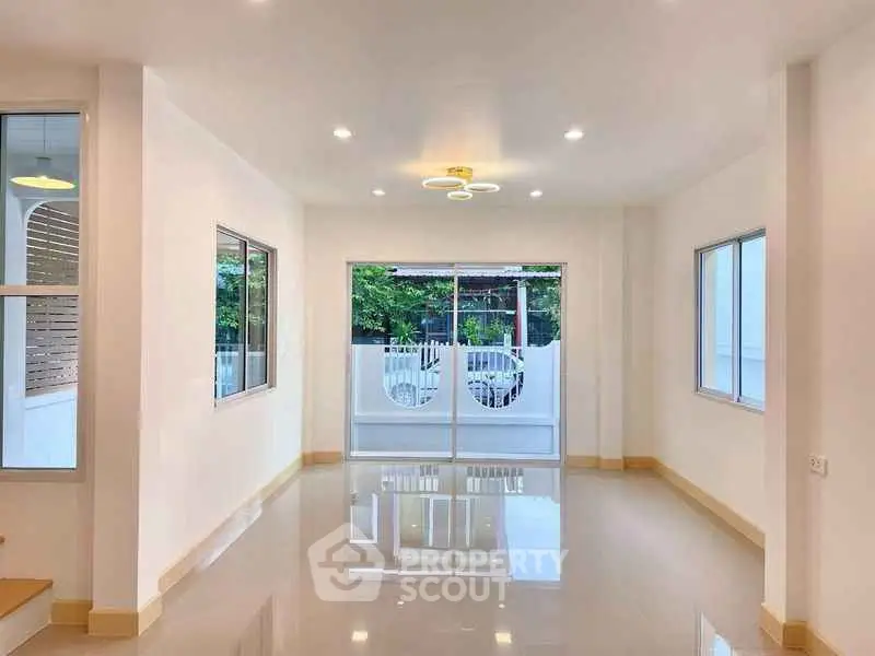 Spacious modern living room with large windows and glossy floors