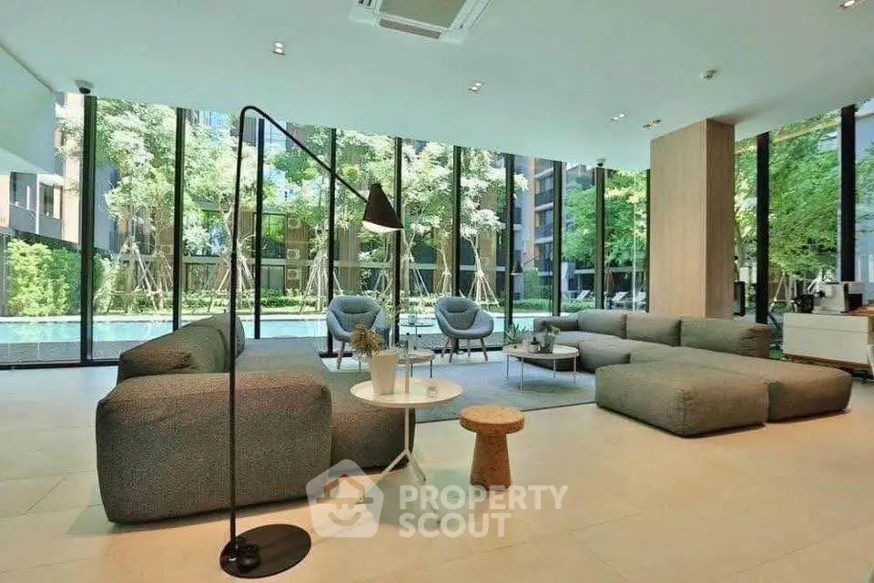 Luxurious modern living room with floor-to-ceiling windows and garden view, featuring stylish furniture.