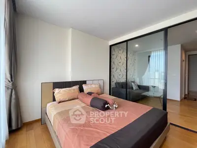 Modern bedroom with elegant decor and glass partition leading to a cozy living area.