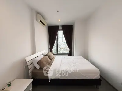 Spacious bedroom with city view, featuring a large bed and modern decor.