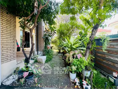 Charming garden pathway with lush greenery and decorative elements in a residential setting.
