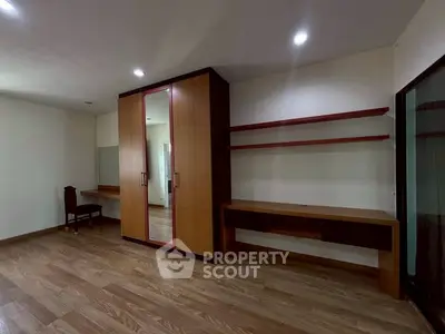 Spacious bedroom with wooden flooring and built-in wardrobe, ideal for modern living.
