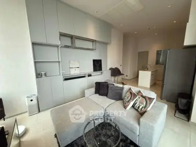 Modern living room with sleek gray furniture and open kitchen layout
