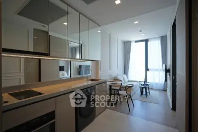 Modern open-layout kitchen and living area with sleek appliances and large windows.