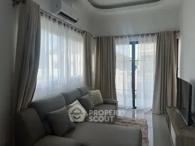 Cozy living room with modern sofa and natural light through large windows.