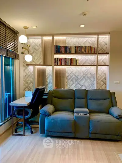Modern living room with cozy sofa and stylish study area, featuring elegant lighting and bookshelf.