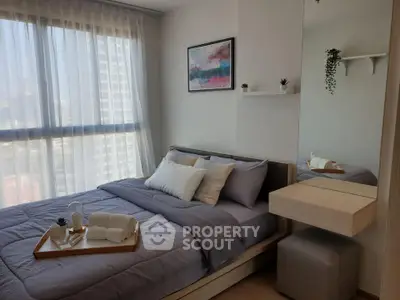 Modern bedroom with large window and stylish decor in a high-rise apartment.