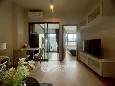 Modern living room with open layout and city view, featuring sleek furniture and natural light.
