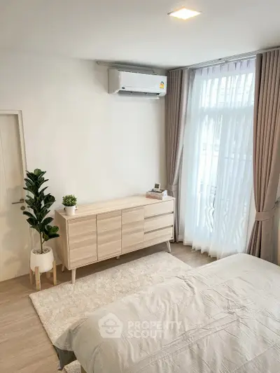 Modern bedroom with natural light, wooden furniture, and elegant decor