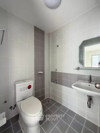 Modern bathroom with sleek gray tiles and contemporary fixtures, perfect for a stylish urban apartment.