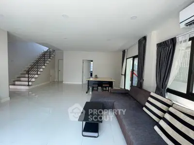 Spacious modern living room with sleek staircase and stylish furniture