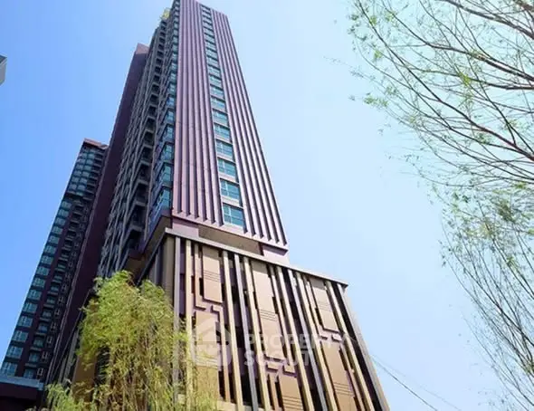 Stunning modern high-rise building with sleek architectural design and lush greenery.