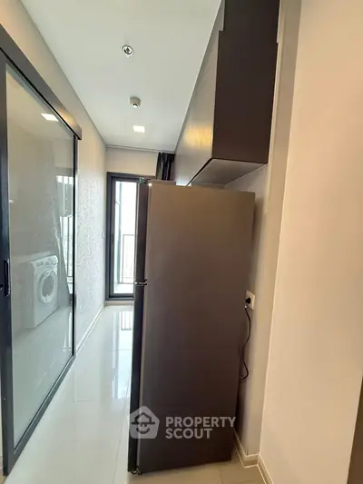 Modern kitchen with sleek fridge and washing machine in compact layout