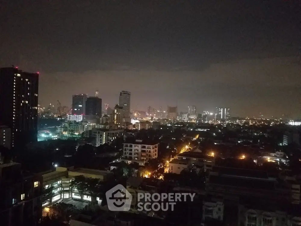 Stunning city skyline view at night with illuminated buildings and vibrant city lights.