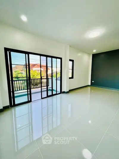 Spacious living room with large windows and balcony access, offering abundant natural light and modern design.