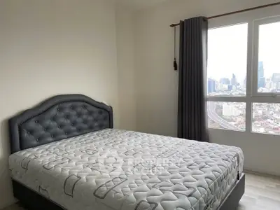 Spacious bedroom with city view and elegant bed in modern apartment