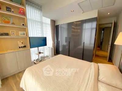 Modern bedroom with sleek design and ample natural light, featuring a stylish wardrobe and cozy ambiance.