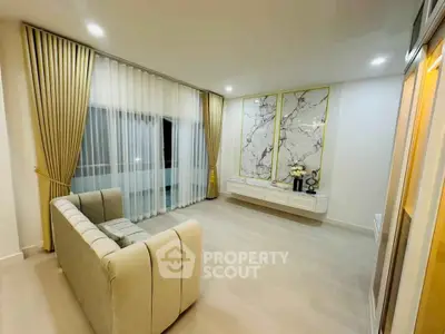 Elegant living room with modern decor and large windows, featuring luxurious curtains and stylish wall art.