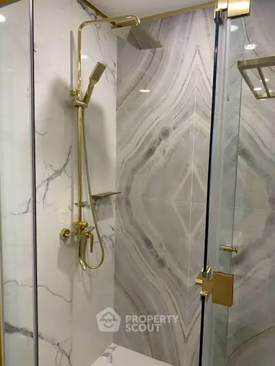 Luxurious bathroom with elegant marble shower and gold fixtures