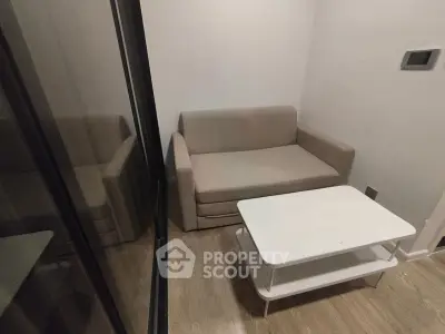 Cozy small living room with beige sofa and white coffee table, perfect for compact spaces.