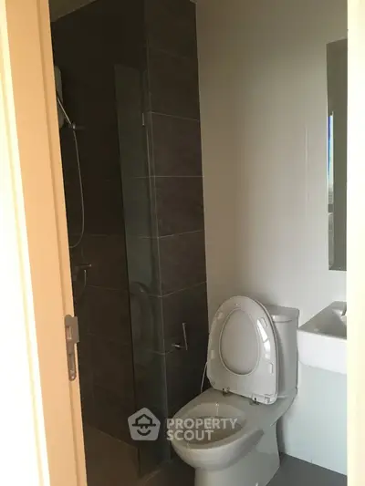 Modern bathroom with sleek shower and toilet in a contemporary apartment.